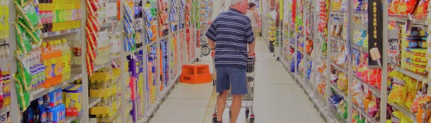 homme avec chariot dans un supermarché