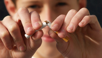 Photo d'un garçon brisant une cigarette