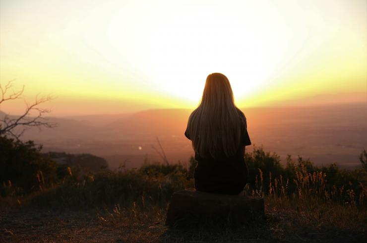 femme devant une ville au coucher du soleil