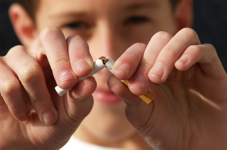 Photo d'un garçon brisant une cigarette